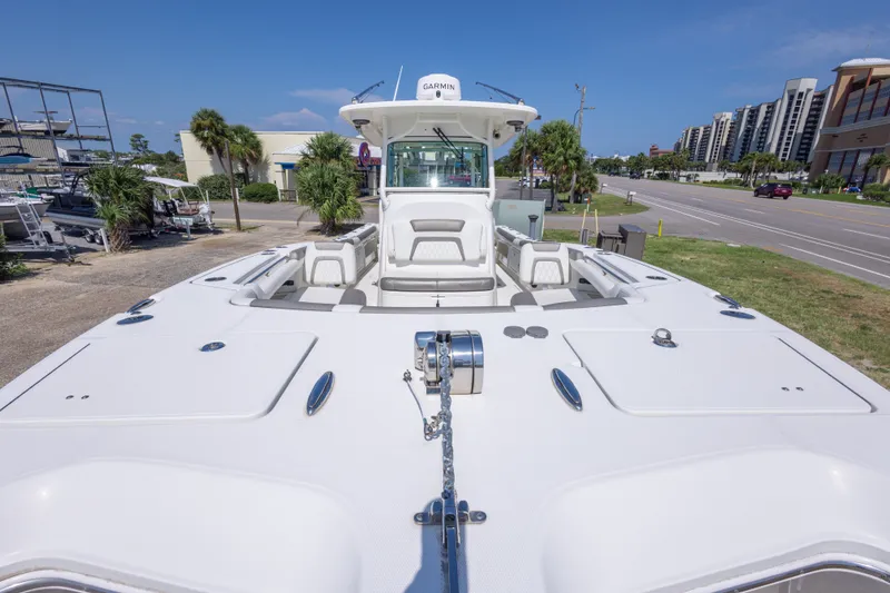 Slide: The Image of 2022 World Cat 325 CC boat docked, showcasing spacious deck and seating area. - 22