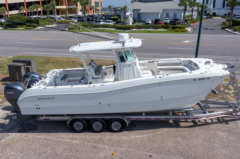Slide: The Image of 2022 World Cat 325 CC boat on trailer, parked near a road. - 2