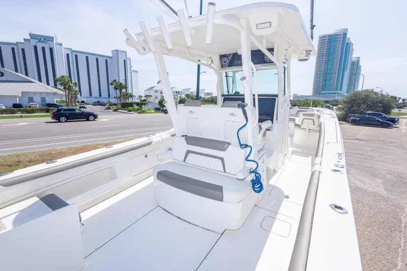 Slide: The Image of 2022 World Cat 325 CC boat with seating, parked near modern buildings. - 25