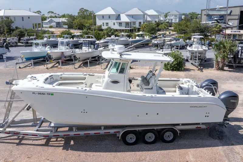 Slide: The Image of 2022 World Cat 325 CC boat on trailer at marina, surrounded by other boats. - 3