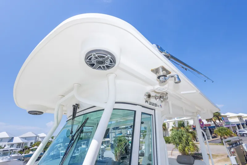 Slide: The Image of 2022 World Cat 325 CC boat with speakers and fishing rod holders, under clear blue sky. - 47