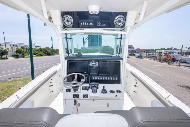 Slide: The Image of 2022 World Cat 325 CC boat cockpit with modern controls and steering wheel. - 28