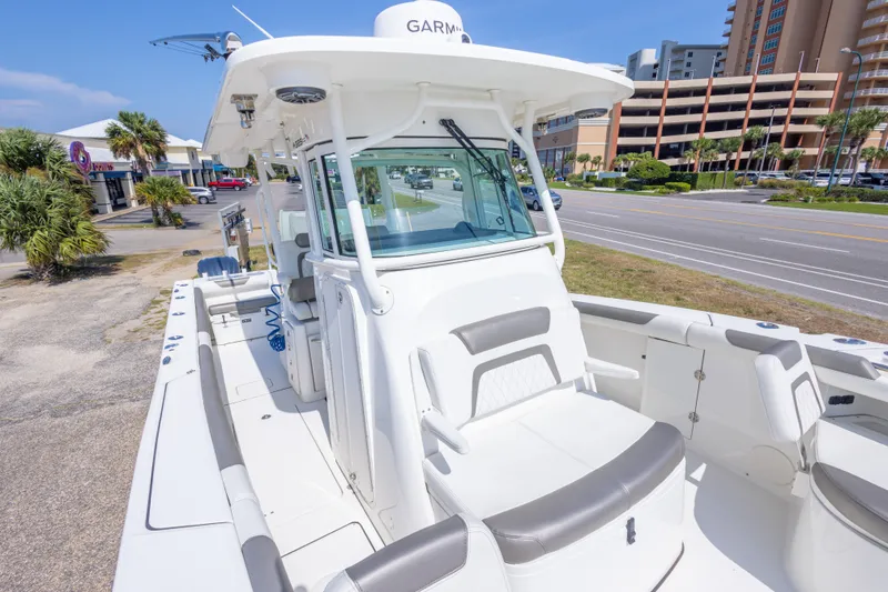 Slide: The Image of 2022 World Cat 325 CC boat with sleek design, docked near a coastal road. - 44