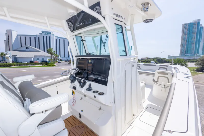 Slide: The Image of 2022 World Cat 325 CC boat interior with modern helm and cityscape background. - 27