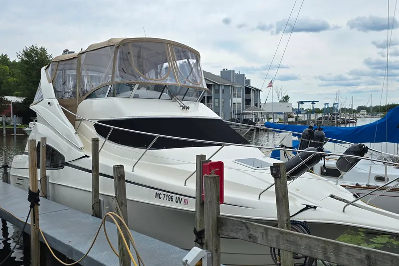 Slide: The Image of 2001 Silverton 330 Sport Bridge yacht docked at a marina, surrounded by other boats. - 1