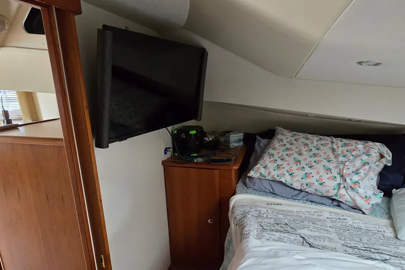 Slide: The Image of Interior cabin of a 2001 Silverton 330 Sport Bridge with bed and mounted TV. - 26