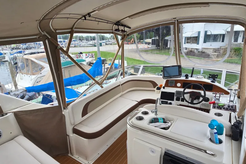 Slide: The Image of 2001 Silverton 330 Sport Bridge interior with helm, seating, and marina view. - 18