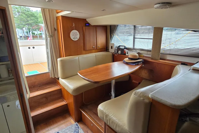 Slide: The Image of Interior of 2001 Silverton 330 Sport Bridge yacht with dining area and windows. - 19