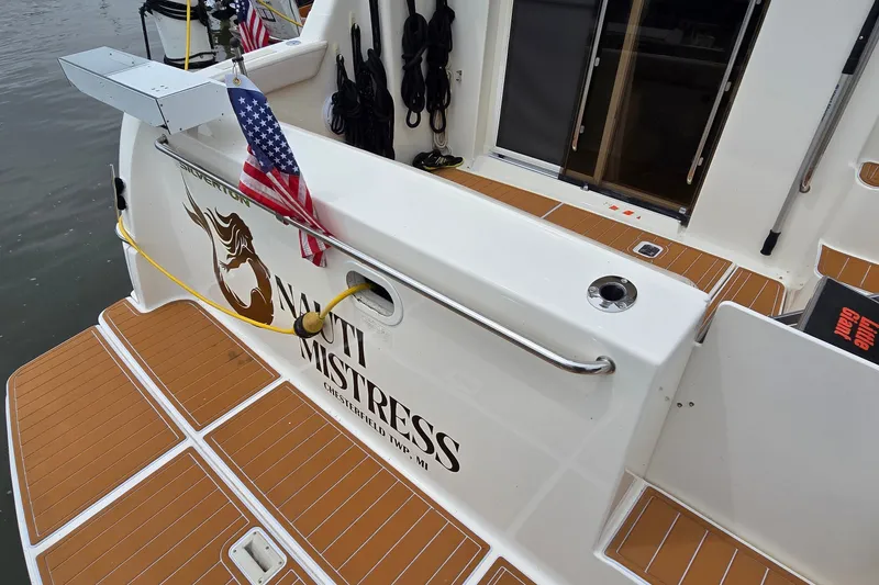 Slide: The Image of 2001 Silverton 330 Sport Bridge boat with "Nauti Mistress" name, docked with American flag. - 6