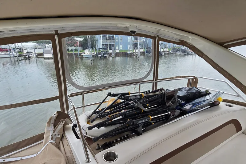 Slide: The Image of 2001 Silverton 330 Sport Bridge interior with folded chairs, overlooking marina. - 17