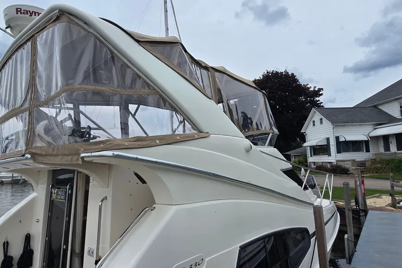Slide: The Image of 2001 Silverton 330 Sport Bridge yacht docked near residential area. - 3