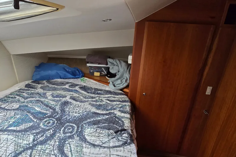 Slide: The Image of Interior cabin of 2001 Silverton 330 Sport Bridge with bed and wooden storage. - 25