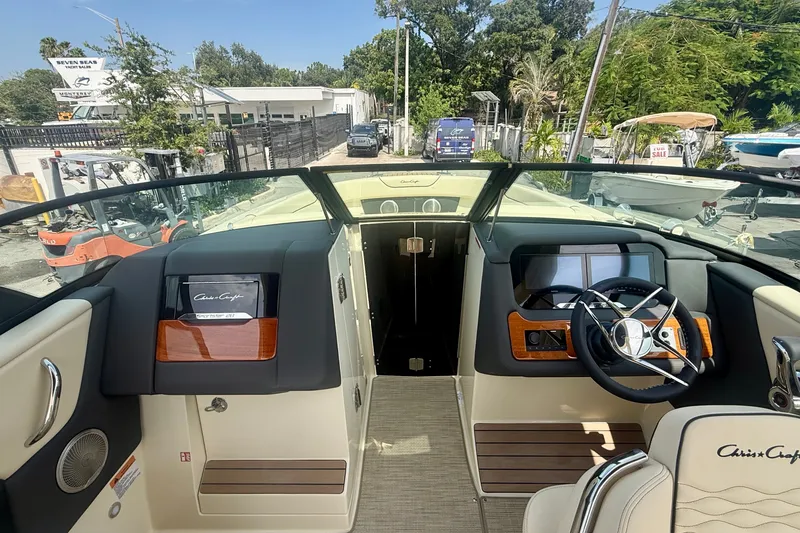 Slide: The Image of 2027 Chris-Craft Sportster 28 OB boat interior with steering wheel and dashboard view. - 24