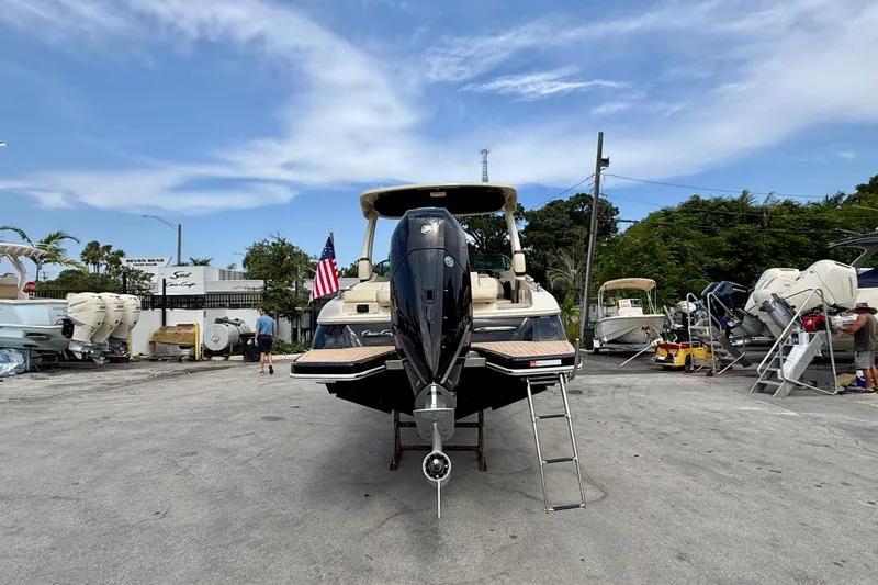 Slide: The Image of 2027 Chris-Craft Sportster 28 OB boat displayed outdoors with American flag. - 29
