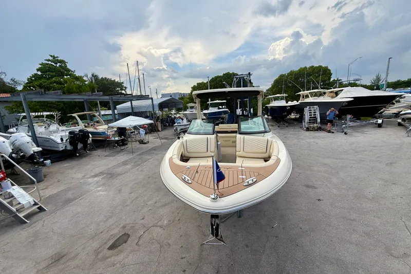 Slide: The Image of 2027 Chris-Craft Sportster 28 OB boat displayed in a marina with other vessels. - 31