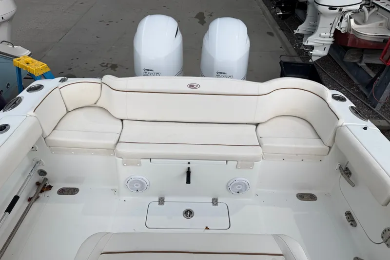 Slide: The Image of 2022 Sea Hunt Ultra 275SE boat interior with white seating and twin Yamaha engines. - 23