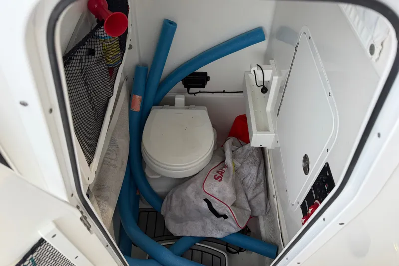 Slide: The Image of Interior of 2022 Sea Hunt Ultra 275SE boat with toilet and storage items. - 15