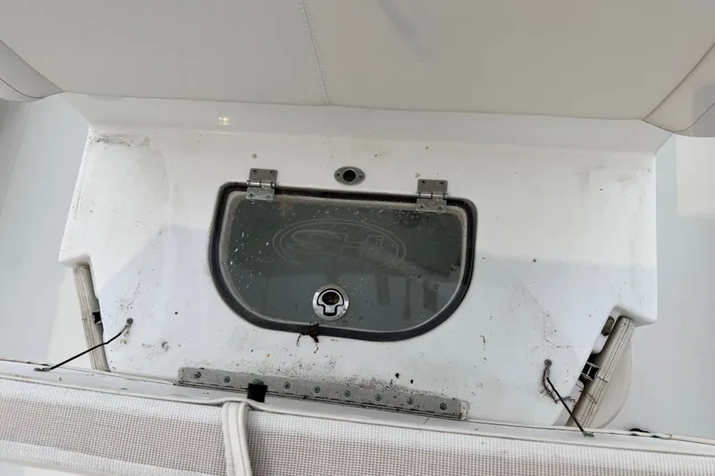 Slide: The Image of 2022 Sea Hunt Ultra 275SE boat storage compartment with hinged lid and latch. - 17