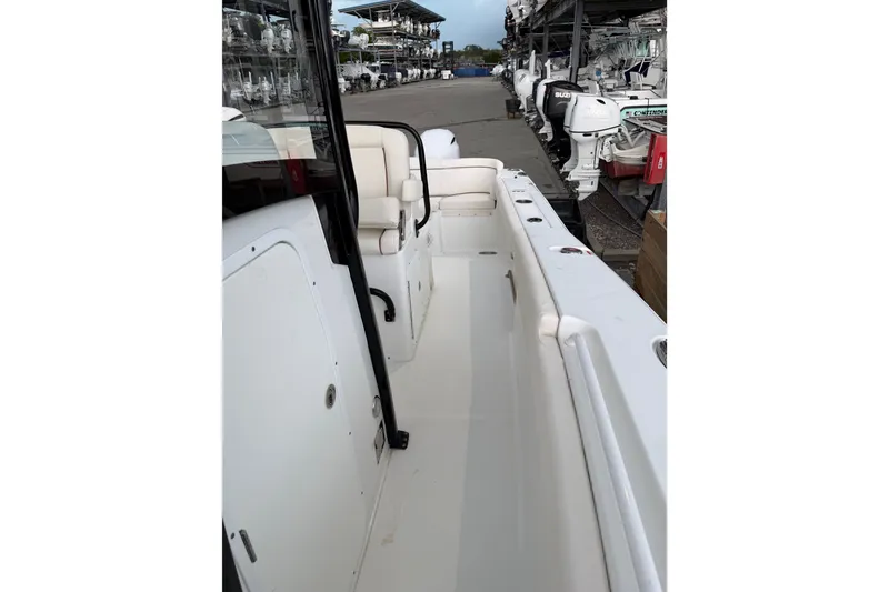 Slide: The Image of 2022 Sea Hunt Ultra 275SE boat interior with seating and storage, docked at a marina. - 8