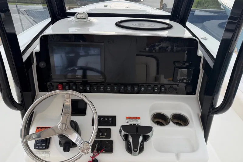 Slide: The Image of 2022 Sea Hunt Ultra 275SE boat dashboard with steering wheel and control panel. - 1