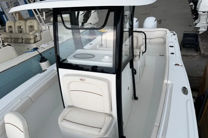 Slide: The Image of 2022 Sea Hunt Ultra 275SE boat interior with seating and console, docked at marina. - 20