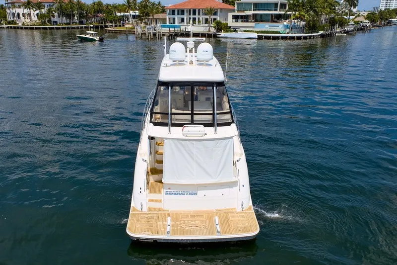 Slide: The Image of 2017 Sea Ray L590 Fly yacht cruising in a scenic waterfront area. - 19