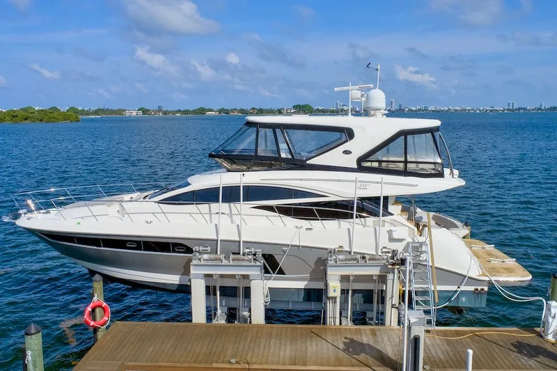 Slide: The Image of 2017 Sea Ray L590 Fly yacht docked by the ocean under a clear blue sky. - 1