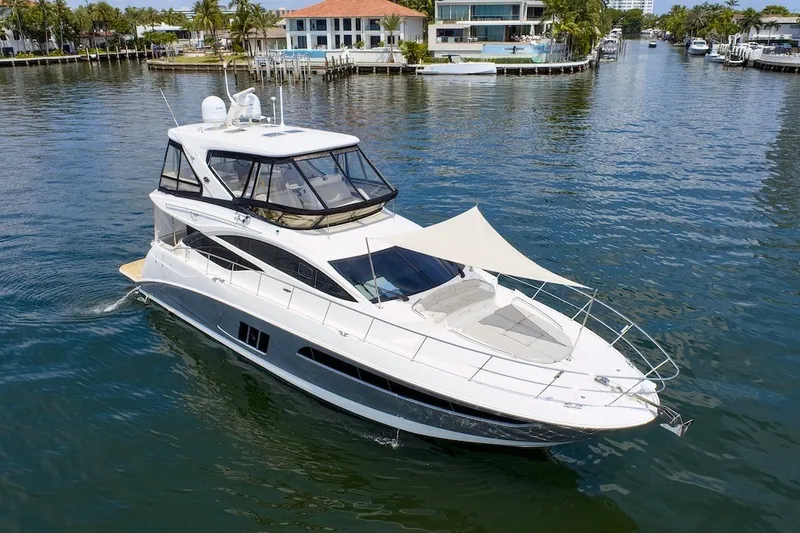 Slide: The Image of 2017 Sea Ray L590 Fly yacht cruising in a scenic waterfront setting. - 17