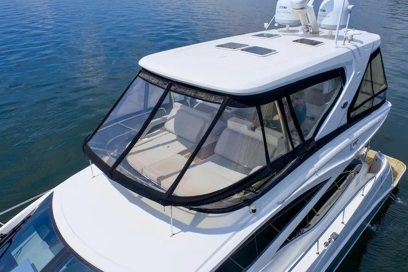 Slide: The Image of 2017 Sea Ray L590 Fly yacht on calm water, featuring a sleek design and spacious flybridge. - 14