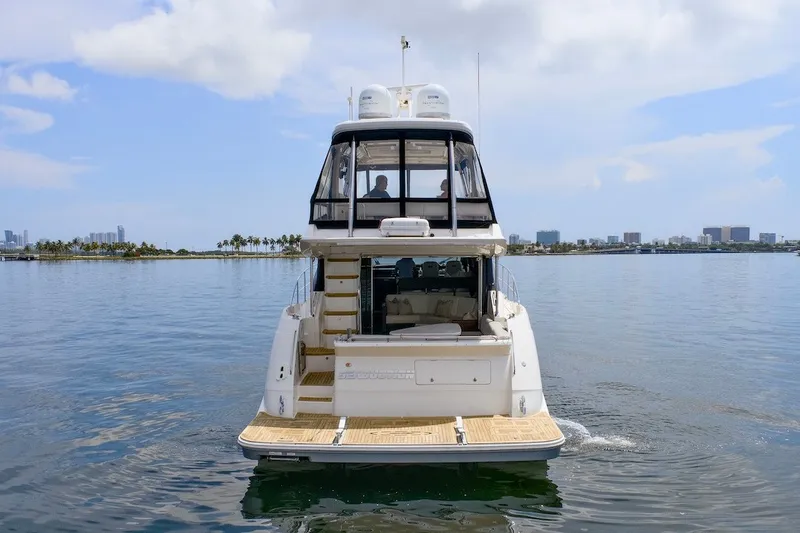 Slide: The Image of 2017 Sea Ray L590 Fly yacht on calm waters with city skyline. - 9