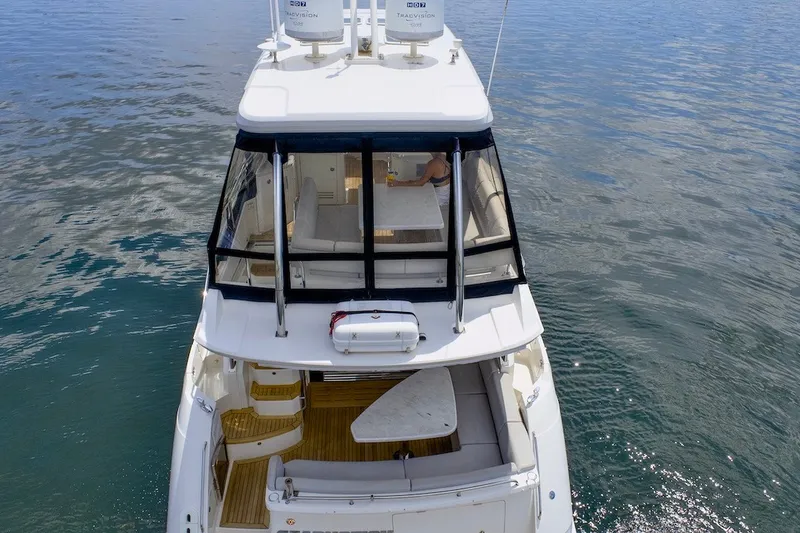 Slide: The Image of 2017 Sea Ray L590 Fly yacht on calm water, showcasing upper deck and seating area. - 15