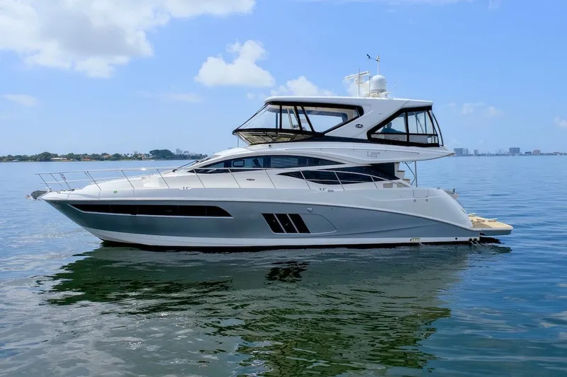 Slide: The Image of 2017 Sea Ray L590 Fly yacht on calm water under a clear blue sky. - 6