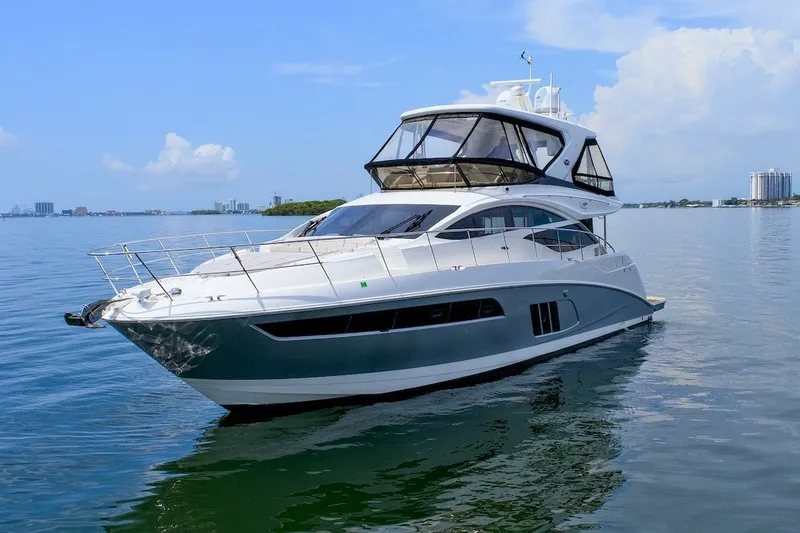 Slide: The Image of 2017 Sea Ray L590 Fly yacht on calm water under a clear blue sky. - 5