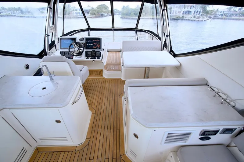 Slide: The Image of Luxurious 2017 Sea Ray L590 Fly yacht interior with helm, seating, and elegant wood flooring. - 33