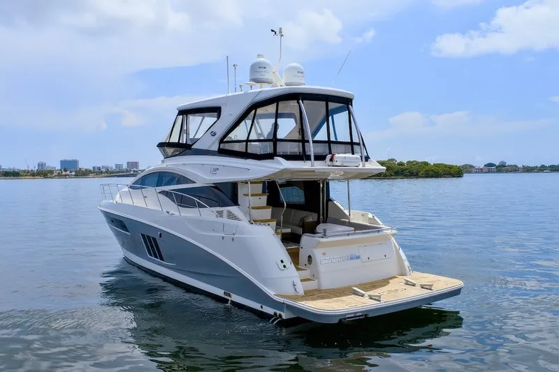 Slide: The Image of 2017 Sea Ray L590 Fly yacht on calm water, showcasing luxury design. - 7