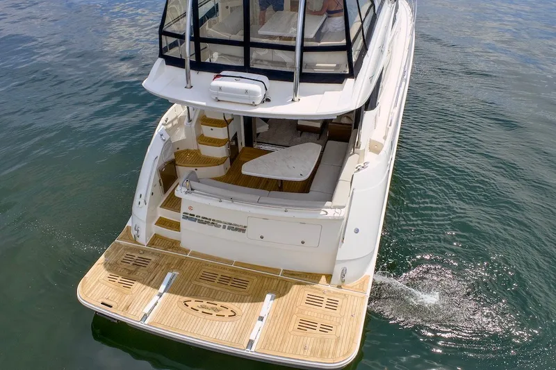 Slide: The Image of 2017 Sea Ray L590 Fly yacht on water, showcasing spacious deck and elegant design. - 10