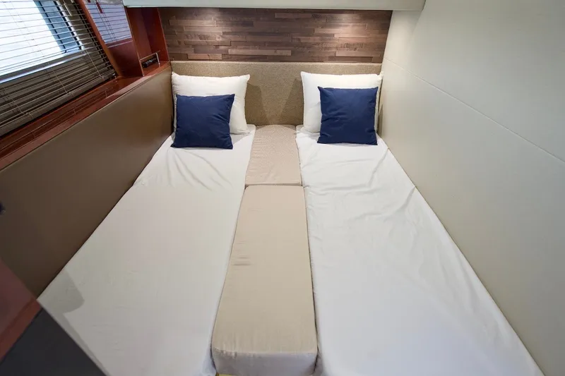 Slide: The Image of 2017 Sea Ray L590 Fly yacht cabin with twin beds and blue pillows. - 64