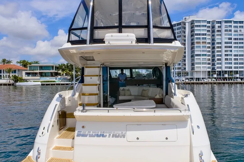 Slide: The Image of 2017 Sea Ray L590 Fly yacht docked near waterfront buildings, showcasing luxurious design. - 20