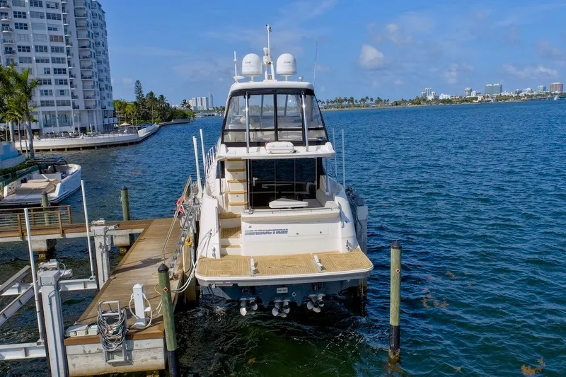 Slide: The Image of 2017 Sea Ray L590 Fly yacht docked at a marina with cityscape background. - 3