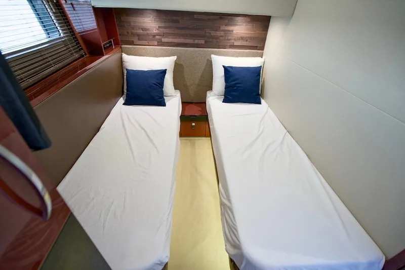 Slide: The Image of Twin beds in the 2017 Sea Ray L590 Fly yacht cabin with blue pillows. - 63