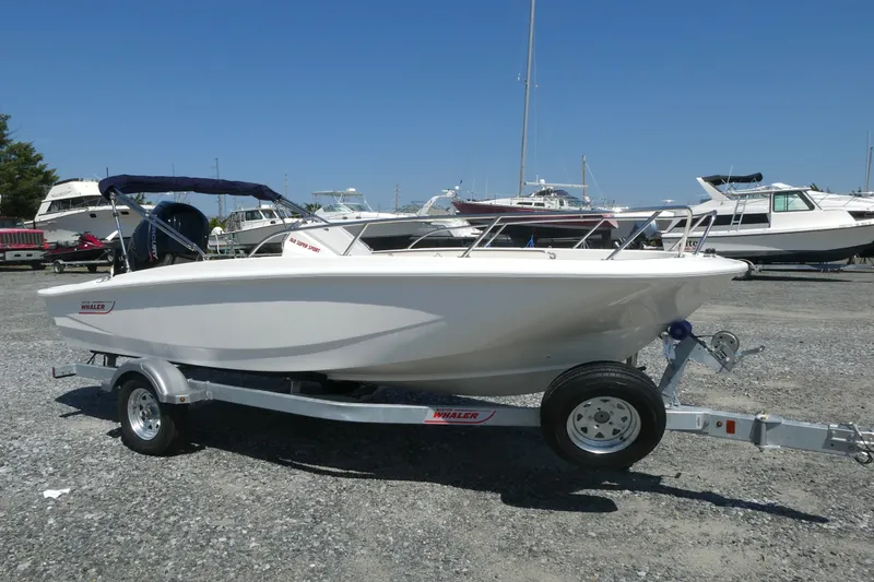 The Image of 2027 Boston Whaler 160 Super Sport boat on trailer, parked in a marina. - 0