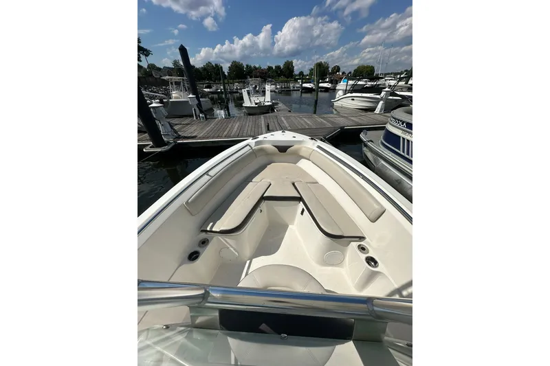 Slide: The Image of 2024 Sailfish 220 CC boat docked at marina under a partly cloudy sky. - 10