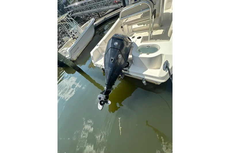Slide: The Image of 2024 Sailfish 220 CC boat with outboard motor docked in marina. - 6