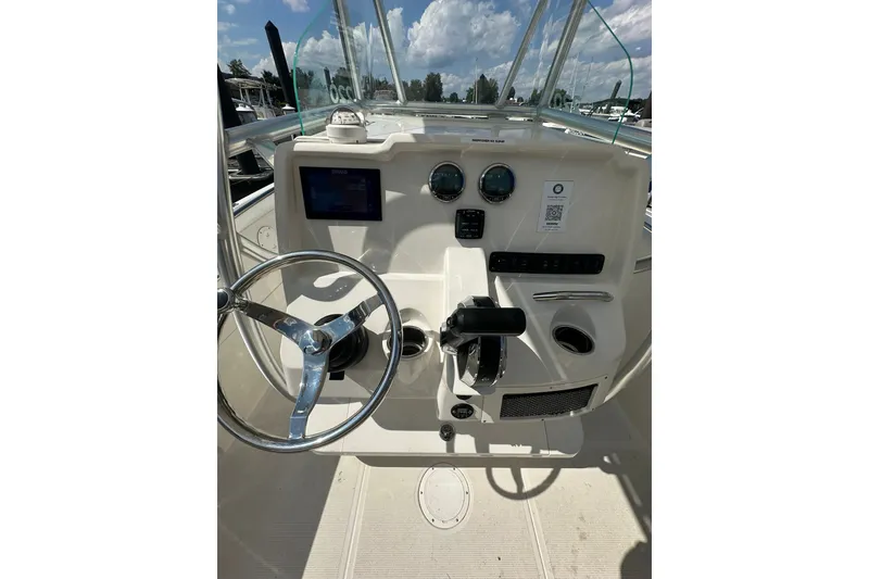 Slide: The Image of 2024 Sailfish 220 CC boat dashboard with steering wheel and control panel. - 9