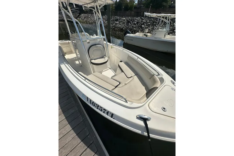 Slide: The Image of 2024 Sailfish 220 CC boat docked, featuring spacious seating and sleek design. - 4