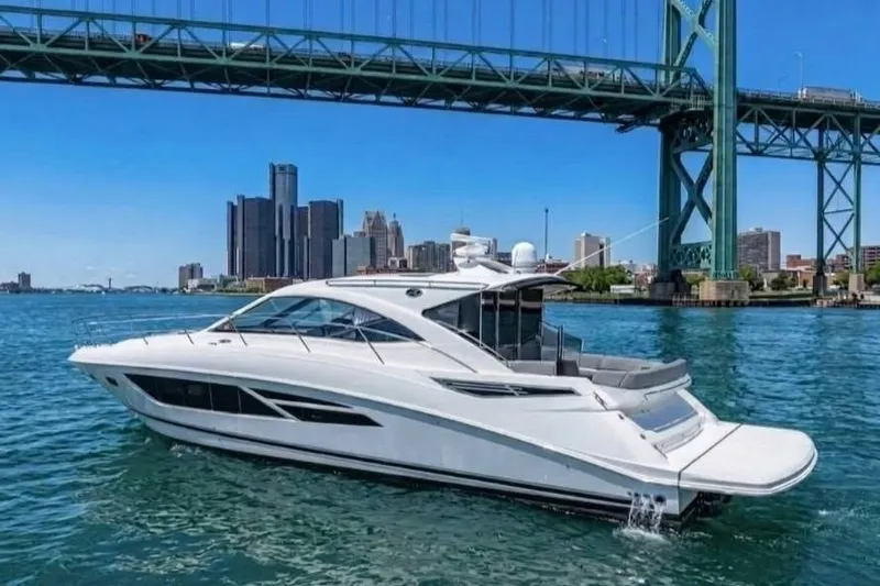 Slide: The Image of 2017 Sea Ray Sundancer 510 yacht cruising under a bridge with city skyline backdrop. - 2