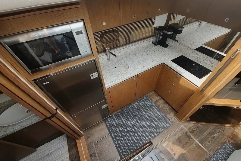 Slide: The Image of Modern kitchen interior of 2017 Sea Ray Sundancer 510 yacht with appliances and wood cabinetry. - 25