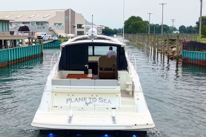 Slide: The Image of 2017 Sea Ray Sundancer 510 yacht navigating a narrow waterway near a marina. - 3