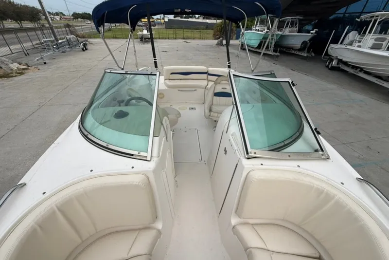 Slide: The Image of 2001 Chaparral 230 SSi boat interior with seating and windshield, docked outdoors. - 15