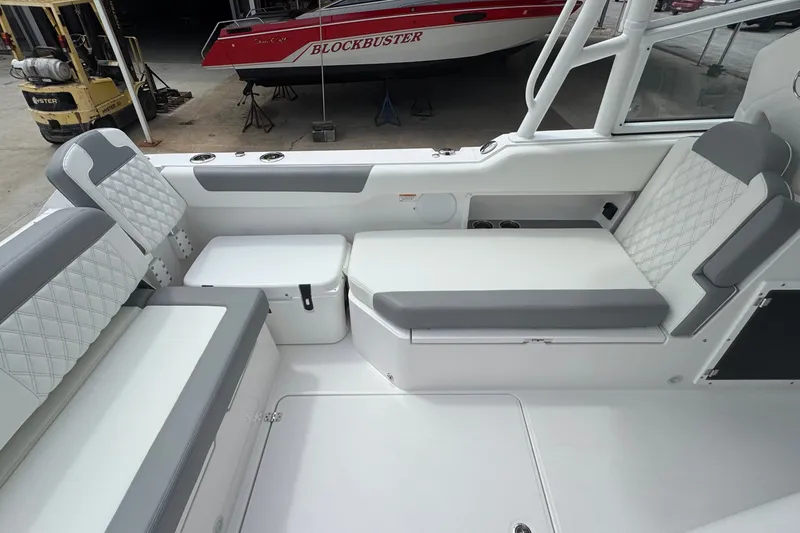 Slide: The Image of 2027 Edgewater 310SC boat interior with cushioned seating and modern design. - 25